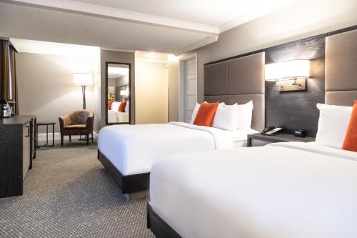 a hotel room with two beds and a chair at Crowne Plaza Fredericton Lord Beaverbrook by IHG in Fredericton