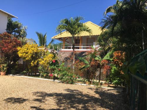 una casa con una recinzione di fronte a un cortile di New Haven Guesthouse a Sosúa