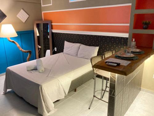 a small bedroom with a bed and a table at Jr FLATS in João Pessoa