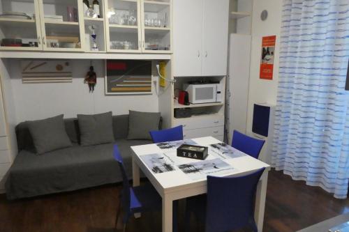 - un salon avec un canapé et une table avec des chaises bleues dans l'établissement Apartment il pescatore di sogni, à Pescara