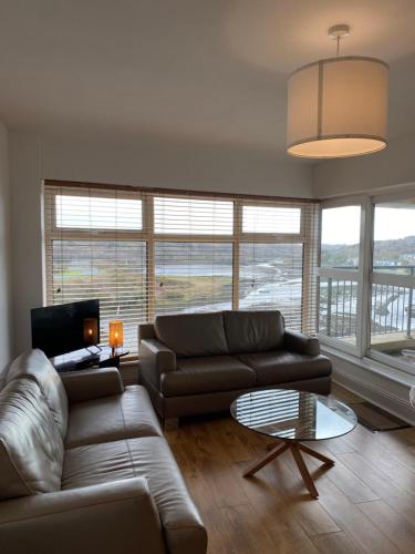 - un salon avec un canapé et une table dans l'établissement Apartment 6 @ Clifden Bay Apartments, à Clifden