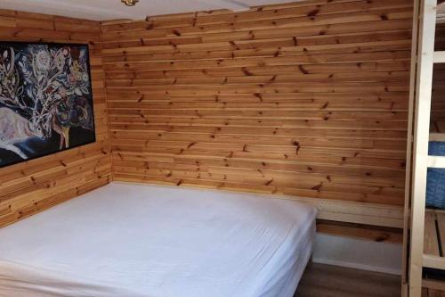 ein Schlafzimmer mit einem weißen Bett an einer Holzwand in der Unterkunft Charming apartment in Old town - great location in Reykjavík