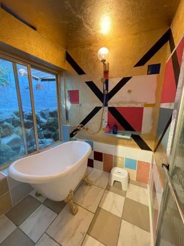 a bathroom with a large tub and a window at XXUFO in Atami