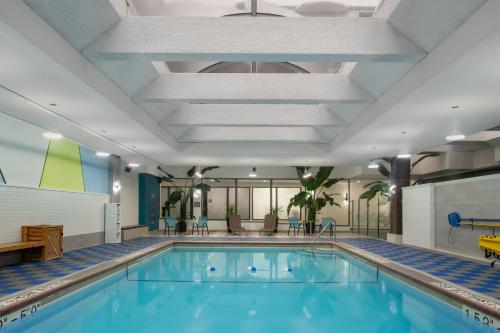 a swimming pool in a hotel room with a large ceiling at Crowne Plaza Kitchener-Waterloo by IHG in Kitchener