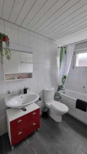 ein Badezimmer mit einem Waschbecken, einem WC und einer Badewanne in der Unterkunft Apartment Cindy in Spiez