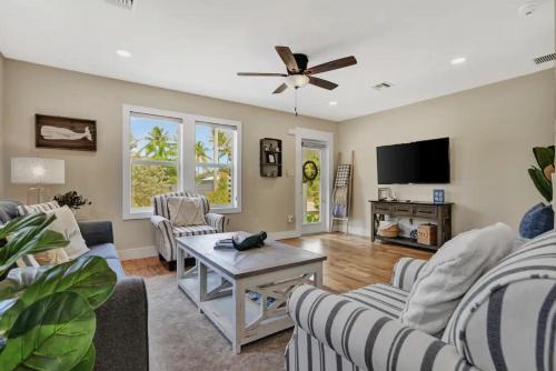 a living room with couches and a flat screen tv at Sabal Palm Vacation Homes in Lake Worth