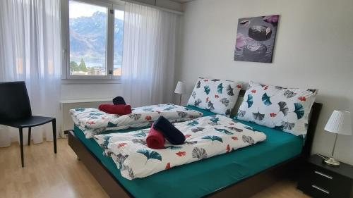 Bett in einem Zimmer mit Sofa und Fenster in der Unterkunft Apartment Cindy in Spiez