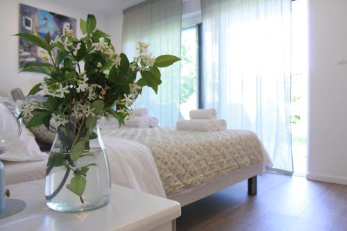 um quarto com uma cama com um vaso de flores sobre uma mesa em Studio Apartment Rosa Krk em Krk