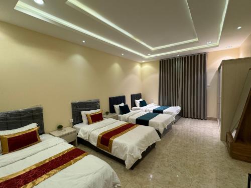a hotel room with three beds in a room at شقة فاخرة غرفتين وصالة النرجس ١٣ in Riyadh