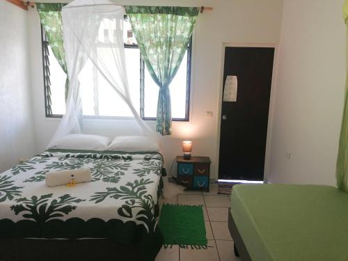 1 dormitorio con cama y ventana en Pension Taitaa Tubuai en Tubuai