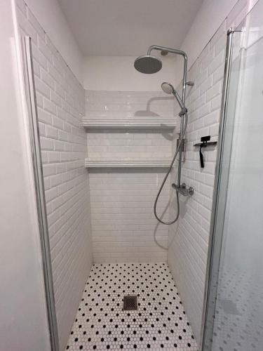 a bathroom with a shower with a black and white floor at Maison Georges in Tourcoing