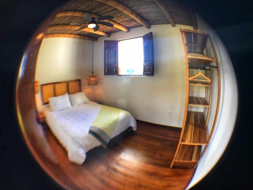 Schlafzimmer mit einem Bett und einem runden Spiegel in der Unterkunft Hacienda La Mesa - Coffee farm in La Paloma