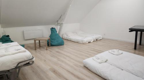 une chambre avec trois lits et une table dedans dans l'établissement Maison typique de village Côte fleurie sur 2 étages proche honfleur, à Équemauville