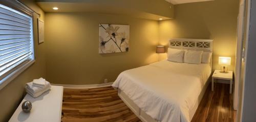 a bedroom with a white bed and a window at Tranquility near the River Complimentary Breakfast in Niagara Falls