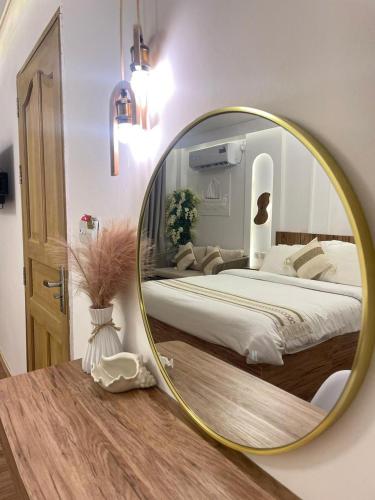 a bedroom with a bed with a round mirror at Sandy Heaven Maldives in Gulhi