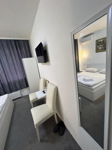 a room with a mirror and a desk and a bed at Pansion Kipovi in Tuzla