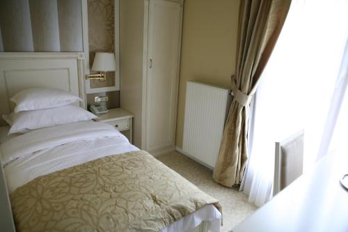 a bedroom with a bed and a window at Hotel Villa Viktorija in Banja Luka
