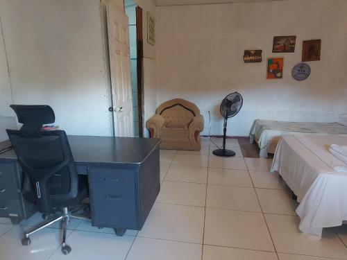 Hostal Brisas del Ometepe في ريفاس: غرفة نوم بسريرين ومكتب وكرسي
