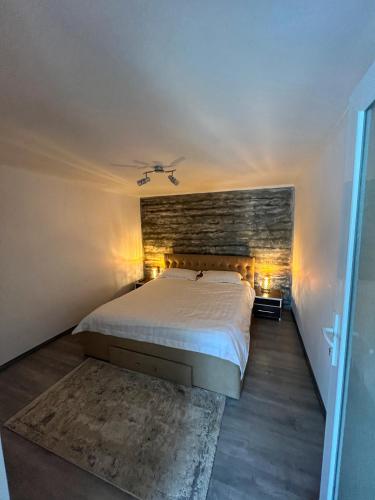 a bedroom with a bed and a brick wall at Casa Dutu in Tuzla