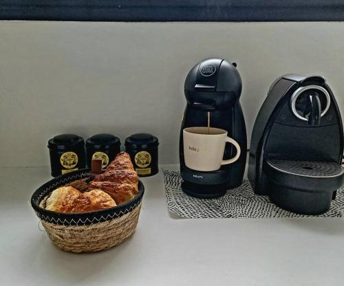 - Comodidades para preparar café, uma cesta de pão e uma chávena de café; em Une maison en ville - Jardin - Au calme em Lorient