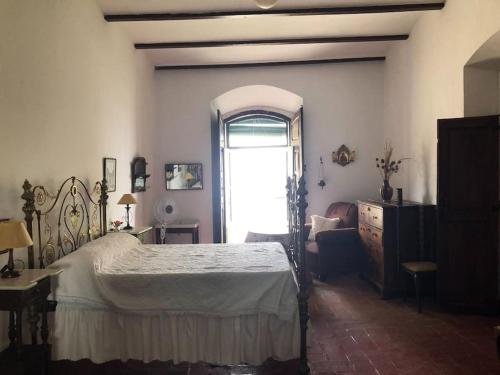 a bedroom with a large bed and a window at Casa rural Santa María del Castillo in Olivenza