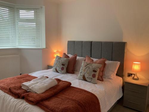 een slaapkamer met een groot wit bed met kussens bij Beautiful 4 Bed House Free WIFI in Earley