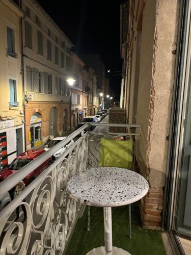 une table sur le balcon d'un bâtiment dans l'établissement Apparemment cosy et chaleureux, à Montauban