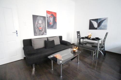 a living room with a black couch and a table at 23Sam Apartment vienna in Vienna