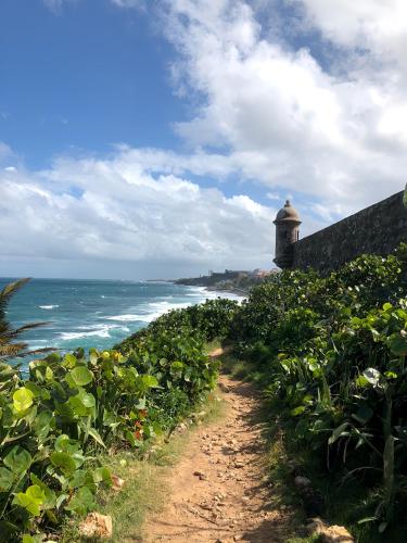a dirt path next to a lighthouse on the beach at Old San Juan Historic Loft 4 The Adventurous in San Juan