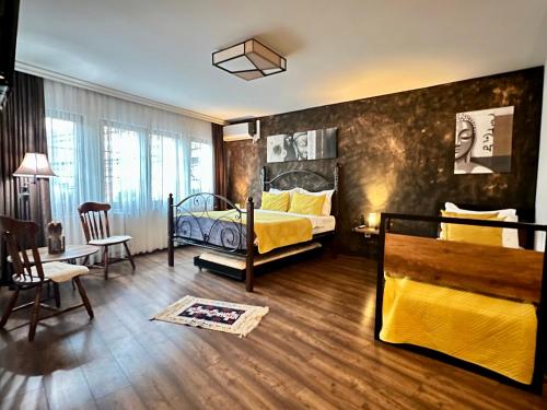 1 dormitorio con 1 cama, mesa y sillas en Hotel Fjorr, en Prizren