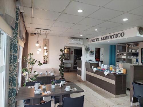 a restaurant with tables and chairs and a counter at Hotel Adriatico in Mar del Plata