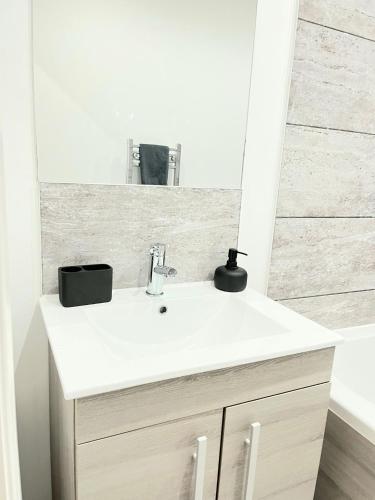 a white bathroom with a sink and a mirror at Leicester City Centre Flat in Leicester
