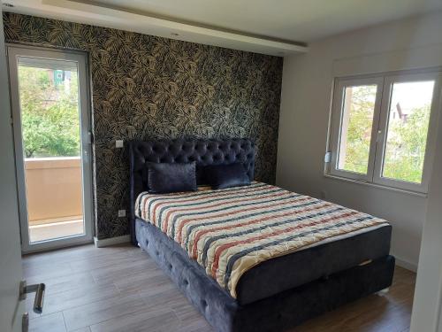Schlafzimmer mit einem Bett mit gemusterter Wand in der Unterkunft Apartman Feniks in Plijeskovo