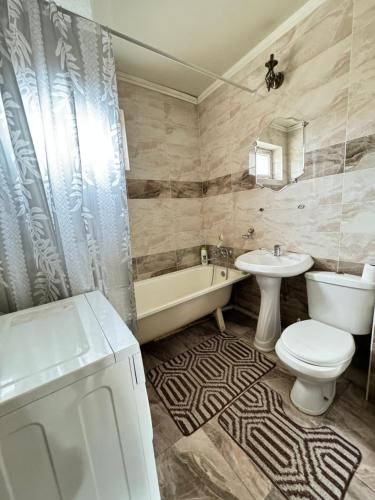 a bathroom with a toilet and a sink and a tub and a toilet istg at 46 Самый центр Идеально для командированных и туристов Чисто оснащенно исправно уютно вместительно in Shymkent