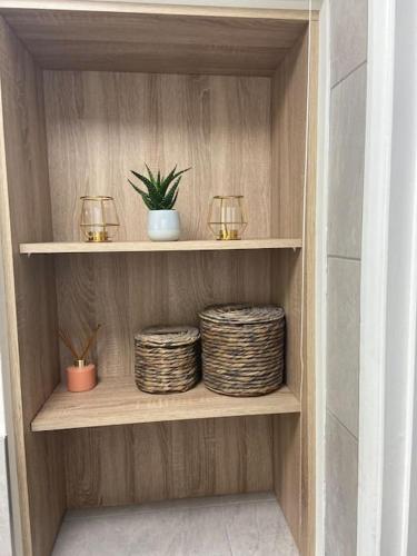 a wooden shelf with two baskets and two candles at Do not book having difficulty removing from page house is not bookable in Derby