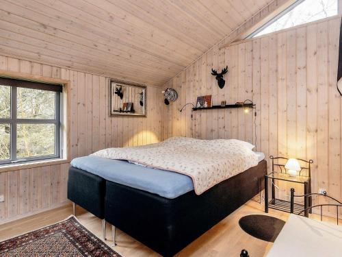 ÅlbækにあるHoliday home Ålbæk IIIの木製の壁のベッドルーム1室(ベッド1台付)