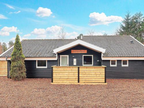 a black house with a wooden fence in front of it at 4 star holiday home in Ålbæk-By Traum in Ålbæk