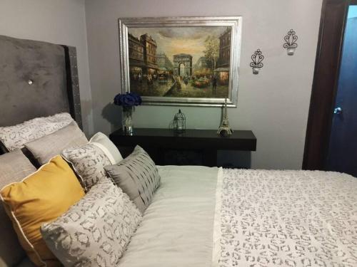 a bedroom with a bed and a painting on the wall at Jardin Imperial in Mexicali