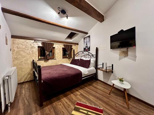 a bedroom with a bed and a flat screen tv at Hotel Fjorr in Prizren