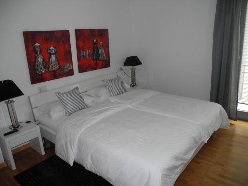 巴特布豪的住宿－Ferienwohnung Central，卧室配有2张白色的床,墙上挂有绘画作品