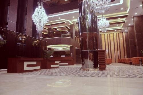 a lobby with chandeliers and a column in a building at Granada Hotel in An Najaf