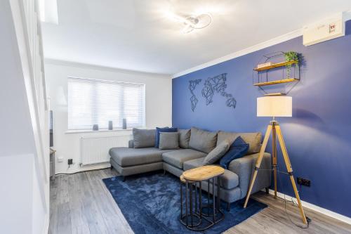 uma sala de estar com um sofá e uma parede azul em UHCW House Coventry em Coventry