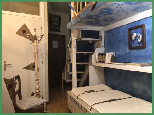 a small room with a bunk bed and a chair at La Finestra sul Fiume in Fossombrone