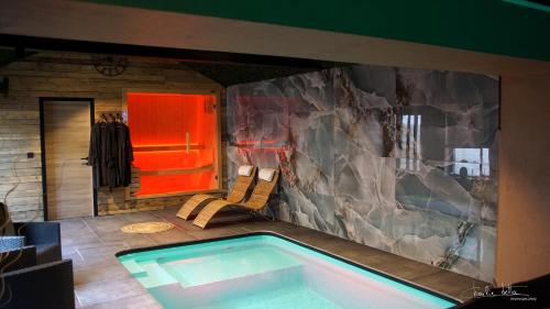 una piscina en una habitación con pared de roca en Nell'aqua, en Seneffe