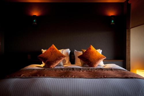 a bedroom with a bed with pillows on it at Isaribi (No Children) in Higashiizu