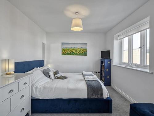a bedroom with a blue bed and a window at Pass the Keys Modern Manchester House with Airport Links in Cheadle