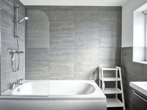 a white bath tub in a bathroom with a ladder at Pass the Keys Modern Manchester House with Airport Links in Cheadle