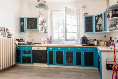 une cuisine avec des armoires bleues et un évier dans l'établissement Maison atypique avec jardin à Évreux, à Évreux
