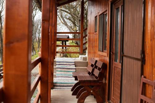 a porch with a wooden bench on a house at Cabana Dealu Capsei in Cîmpeni