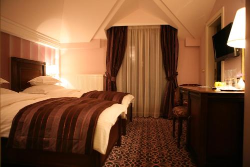 a hotel room with two beds and a table at Hotel Villa Viktorija in Banja Luka